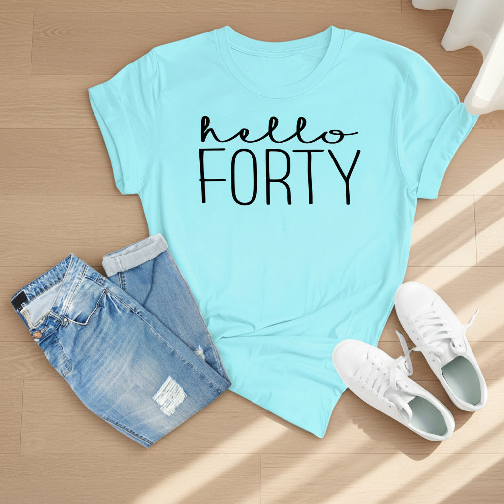 A light blue graphic t-shirt with 'hello FORTY' printed in black across the chest, styled in a flat lay with distressed denim shorts and white sneakers on a wooden plank background.
